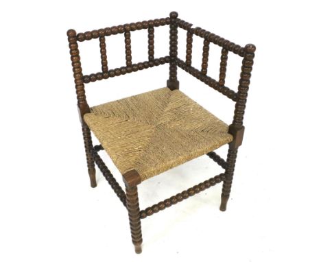 A 19th centuy oak bobbin turned corner chair. With a rush envelope seat, H71cm