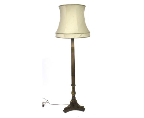 An early 20th century mahogany and gilded standard lamp. The stand of reeded form, mounted on a tripod support with carved de