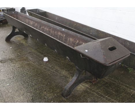 A 19th century large cast iron horse trough. finished in black, bolted onto bowed tapering supports complete with lid, H92cm 