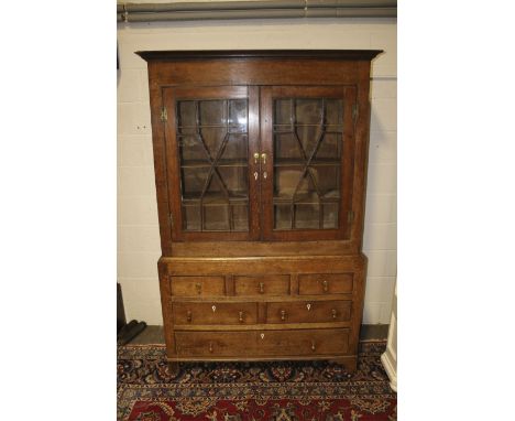 A Georgian two section astral glazed oak display cabinet. Top section of two glazed doors with three interior shelves. Bottom