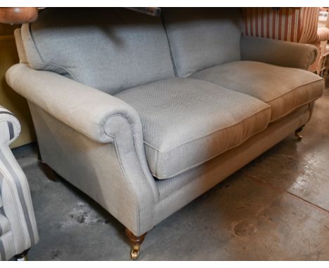 Laura Ashley - a two-seater scroll arm sofa in stone linen-blend fabric on hardwood suports with brass castors, 180 x 100 x 9