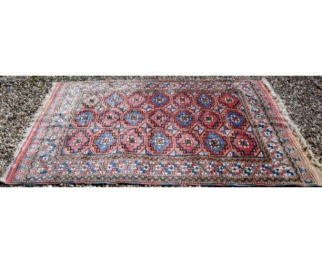 A Turkish gul-tile design terracotta ground rug, cream repeating border, 210 x 130 cm 