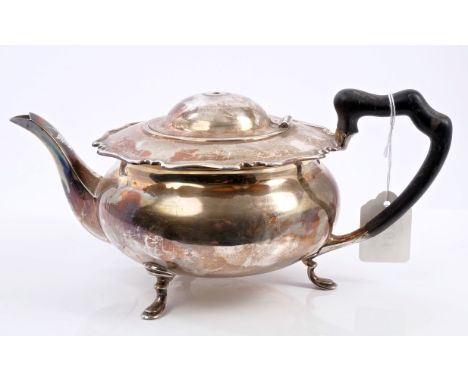 Early George V silver teapot of compressed baluster form, with flared scroll border, ebony handle and hinged domed cover (fin