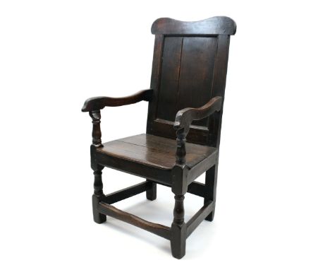 Antique oak Wainscott chair with shaped top rail and panel back, solid seat flanked by shaped arms, on turned and block under