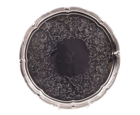 Victorian silver salver of circular form, with chased and engraved floral decoration, engraved armorial crest and reed and ri