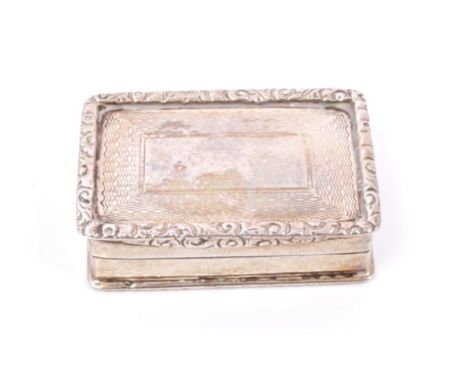 George V silver vinaigrette of rectangular form, with engine-turned decoration and raised foliate border, hinged cover with v