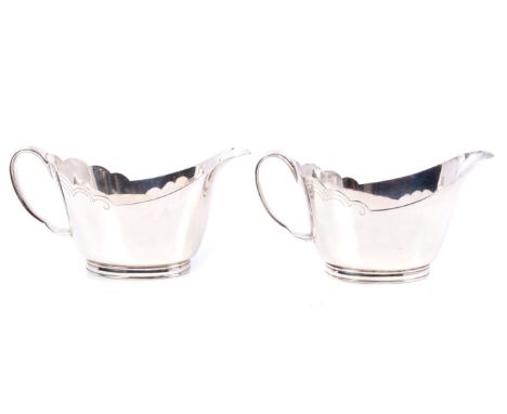 Pair contemporary silver sauce boats of inverted helmet form, with engraved wavy borders, ribbon handles, on oval feet, engra