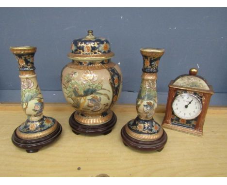 Oriental garniture of lidded vase and candlesticks on wooden bases with matching clock&nbsp;