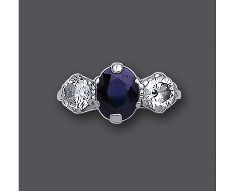 A THREE STONE SAPPHIRE AND DIAMOND RING, the central oval facet cut sapphires flanked by two claw set brilliant cut diamonds 