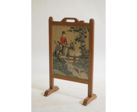 AN OAK FIRESCREEN BY ROBERT THOMPSON, of oblong form with gros point panel depicting a huntsman, the straight top rail with a