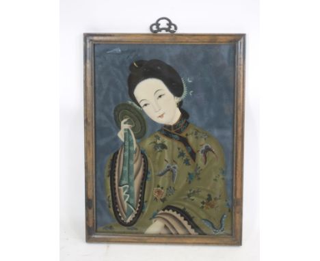 A CHINESE REVERSE PAINTING ON GLASS, painted in sombre colours with the half length portrait of a young lady holding a circul