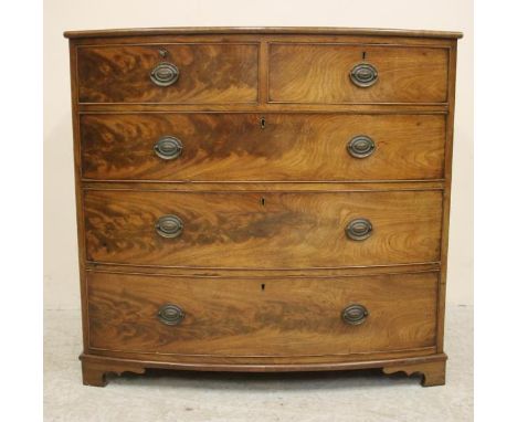 A GEORGIAN MAHOGANY CHEST, c.1800, of bowed form, the moulded edged top over two short and three long cockbeaded drawers with