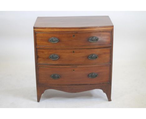 A SMALL MAHOGANY CHEST of bowed form with stringing, the caddy top over three graduated drawers with oval brass drop handles,