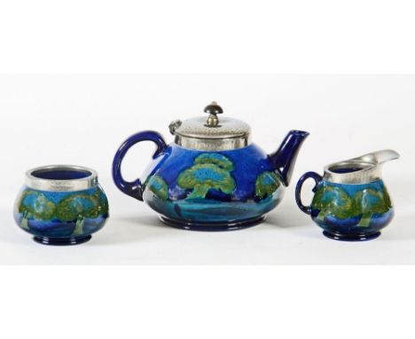 A MOORCROFT POTTERY THREE PIECE TEA SERVICE, 1920's, of squat globular form, tubelined and painted in blue and green with the