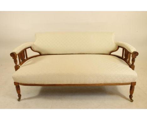 A LATE VICTORIAN ROSEWOOD SOFA of low rounded form, with foliate marquetry panels and stringing, and upholstered in an ivory 