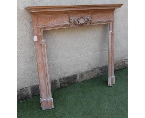 A CARVED PINE CHIMNEY PIECE of Georgian design, 20th century, the moulded edged shelf with head and reel banding, frieze with