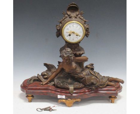 Circa 1900, a French painted metal figural mantel clock, the central female figure flanked by dolphins 50 x 55 x 24cmdial gla