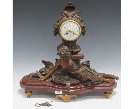 Circa 1900, a French painted metal figural mantel clock, the central female figure flanked by dolphins 50 x 55 x 24cmdial gla