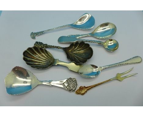 An Art Nouveau caddy spoon, enamelled fork and six other spoons