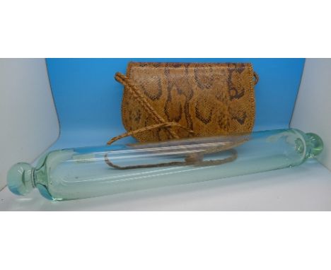 An early 20th Century glass rolling pin and a snakeskin handbag