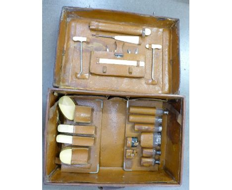 A gentleman's early 20th Century leather travel case with six silver topped glass bottles, vesta, inkwell, brushes, manicures