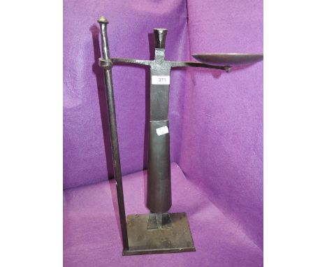 A figural candle stick in wrought iron