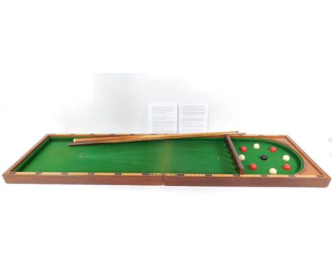 A Victorian mahogany cased bagatelle, with balls, together with two cues and two laminate pages of instructions for various b