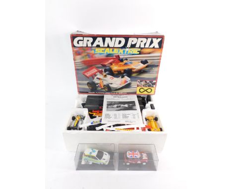 A Scalextric Grand Prix racing set, C573, boxed, together with a Ford Focus Police Car and a Mini Cooper, both boxed. (3)
