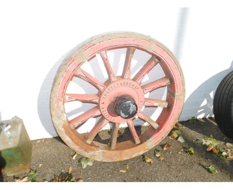 A Clayton & Shuttleworth Ltd wooden traction engine wheel, with a cast iron hub cap, painted in red and detailed in black and