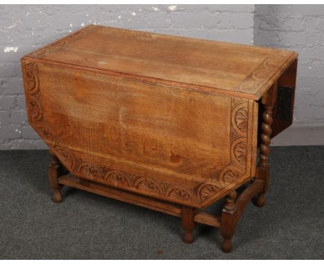 A carved light oak drop leaf dining table.  