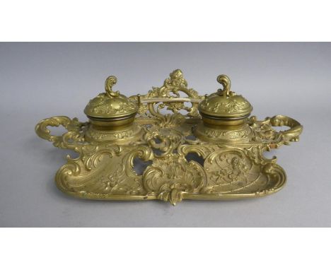A Reproduction French Style Brass Ink Stand with Pen Rest and Two Ceramic ined Ink Wells, 34cms Wide 