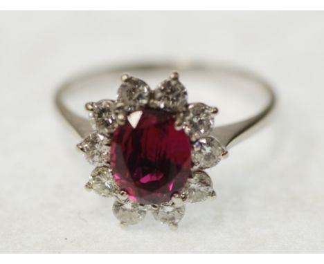 RUBY AND DIAMOND CLUSTER RING, claw set with oval mixed cut ruby and a surround of ten round brilliant cut diamonds, 0.50ct a