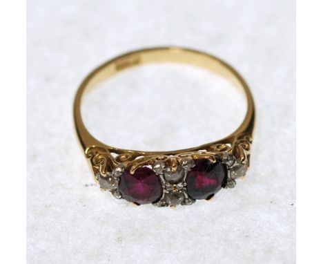 RUBY AND DIAMOND SET RING, boat shaped top set with two oval mixed cut rubies and a surround of four old and brilliant cut di