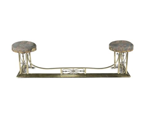 AN ART NOUVEAU BRASS PIERCED FENDER, with two upholstered circular seats at each end, above intertwined geometric floral pane