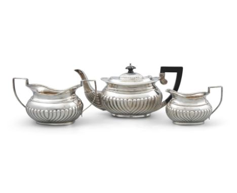 AN EDWARDIAN SILVER THREE PIECE BACHELOR'S TEA SERVICE, Birmingham c.1905, maker's marks rubbed, with gadroon rim and reeded 