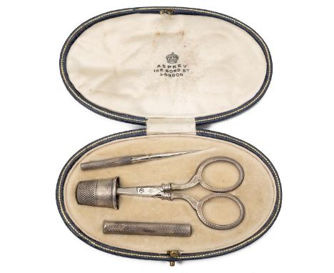 Four-piece travelling sewing set by Asprey 166 Bond Street comprising a needle case, thimble, scissors and needle.