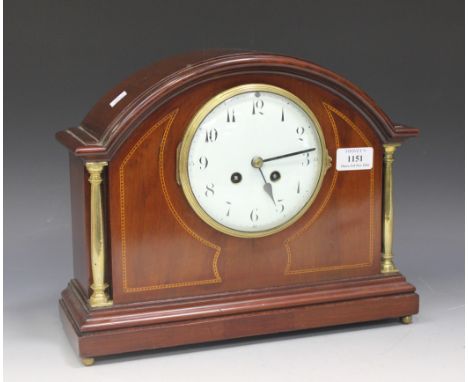 An Edwardian mahogany mantel clock with eight day movement striking on a gong, the circular enamel dial with Arabic numerals,