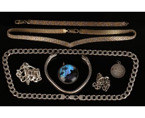 A group of mostly silver and silver gilt jewellery, comprising a faceted curblink neckchain, two bracelets, an Eastern bangle