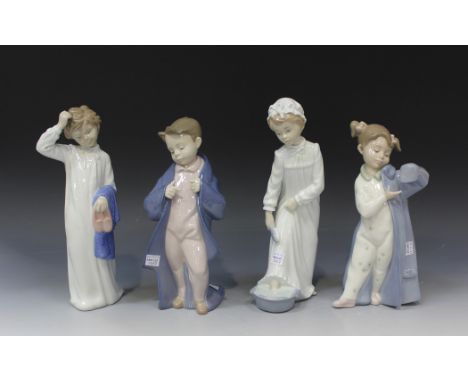 A group of four Nao porcelain figures, comprising Boy Washing Feet, No 231, Boy with Slippers, No 232, My Daddy's Coat, No 13