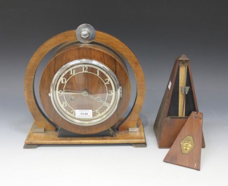 An Art Deco walnut mantel clock with eight day movement striking on a gong, the chrome chapter ring with Arabic numerals, the