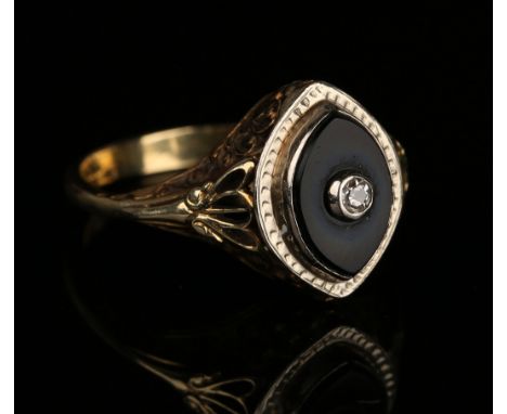 A gold, diamond and black onyx ring, the boat shaped black onyx mounted with a cushion shaped diamond within a scroll pierced