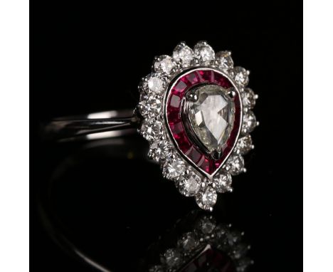 An 18ct white gold, diamond and ruby cluster ring, claw set with a pear shaped diamond within a surround of tapered baguette 