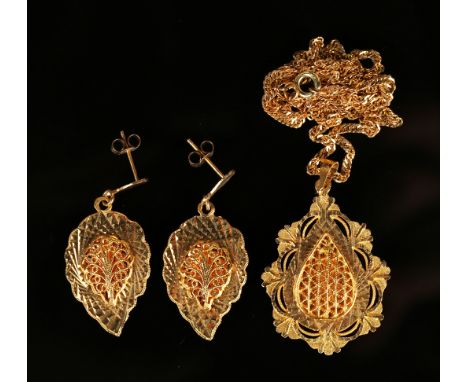 A Middle Eastern gold pendant, the filigree centre framed by a pierced foliate surround, detailed '21K', with a neckchain, an
