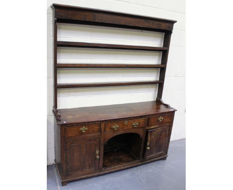 An 18th Century oak dresser, the moulded pediment above three shelves, the base fitted with three drawers above a central she