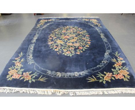 A Chinese carpet, mid-20th Century, the blue field with a foliate medallion, approx 344cm x 250cm.