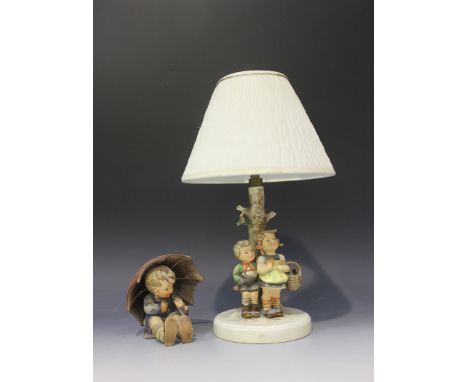 A Goebel Hummel 'To Market' lampbase, modelled as two children standing by a tree, on a circular base, height approx 42cm, to