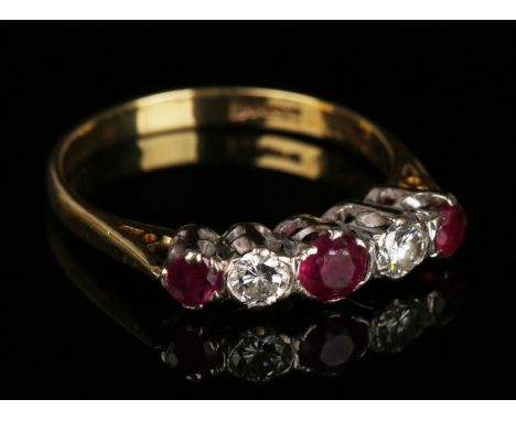 An 18ct gold, ruby and diamond five stone ring, mounted with three cushion shaped rubies alternating with two circular cut di