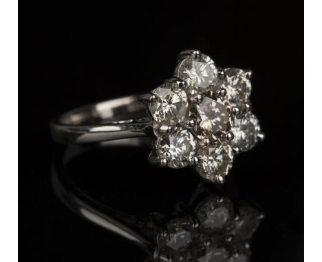 An 18ct white gold and diamond cluster ring, claw set with a circular cut champagne diamond within a surround of six circular