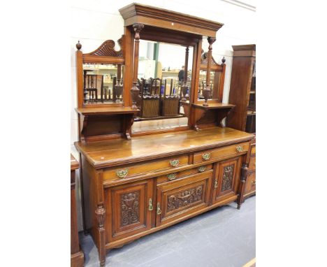 A late Victorian walnut sideboard, the mirror and shelf back above an arrangement of three drawers and cupboards, raised on t