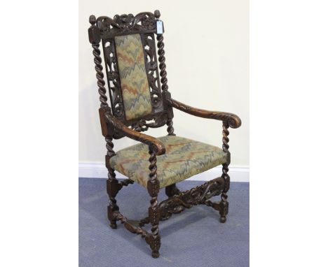 A Charles II and later walnut elbow chair, carved with angels' masks and leaf and flower scrolls, the seat and back upholster